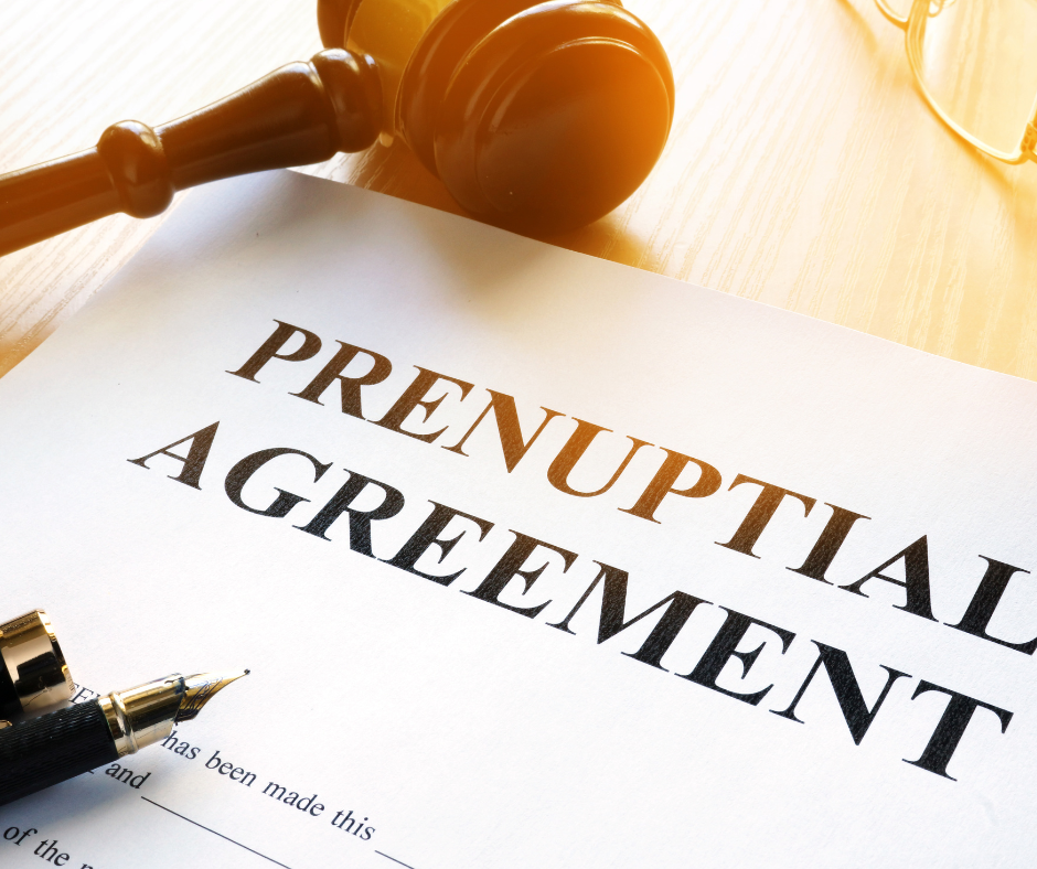 The document is open and visible, showing legal text and signatures. The image symbolises the legal and financial aspects of prenuptial agreements.